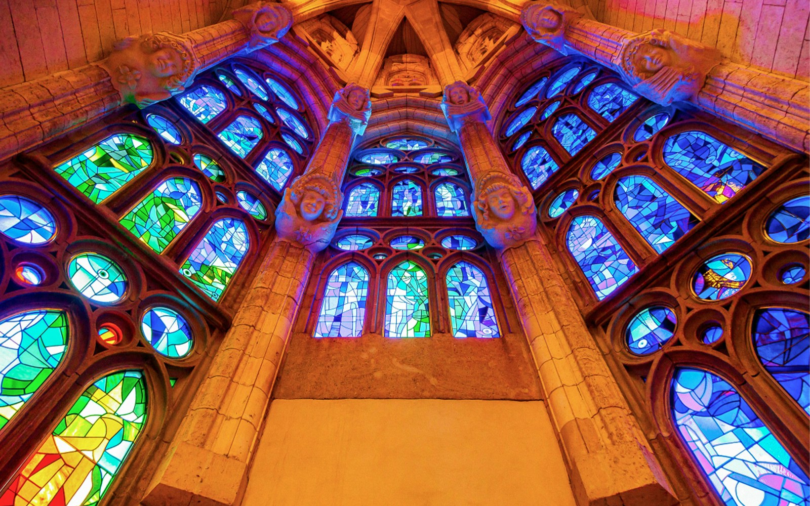 Stained glass windows inside Sagrada Familia, Barcelona, showcasing vibrant colors and intricate designs.