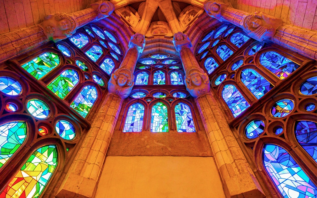 Stained glass windows inside Sagrada Familia, Barcelona, showcasing vibrant colors and intricate designs.