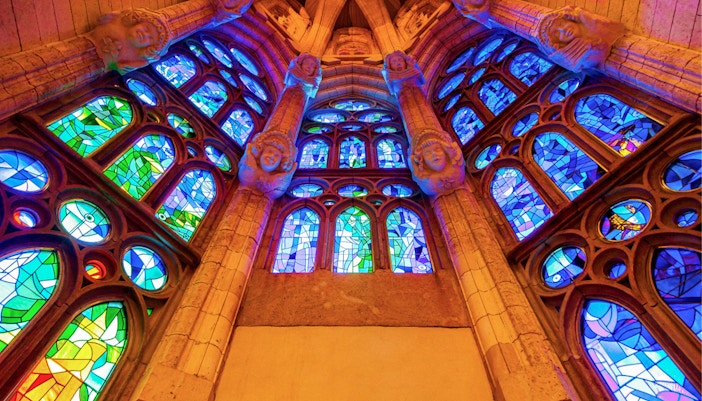 Stained glass windows inside Sagrada Familia, Barcelona, showcasing vibrant colors and intricate designs.