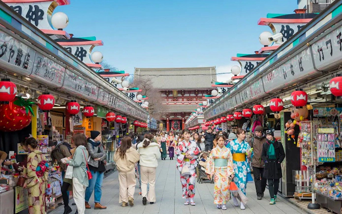Visitors walking along Nakamise-dori Street towards Senso-ji Temple in Asakusa, Tokyo.