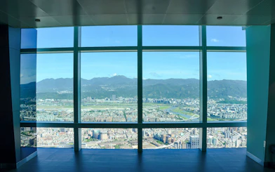 View of Taipei cityscape and mountains from Taipei 101 observation deck.