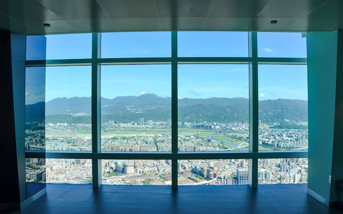 View of Taipei cityscape and mountains from Taipei 101 observation deck.