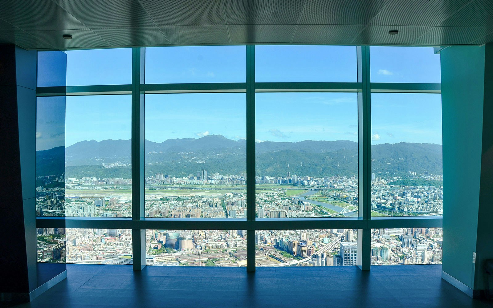 View of Taipei cityscape and mountains from Taipei 101 observation deck.