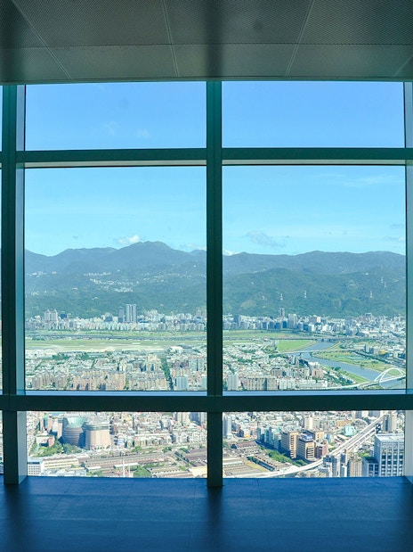 View of Taipei cityscape and mountains from Taipei 101 observation deck.
