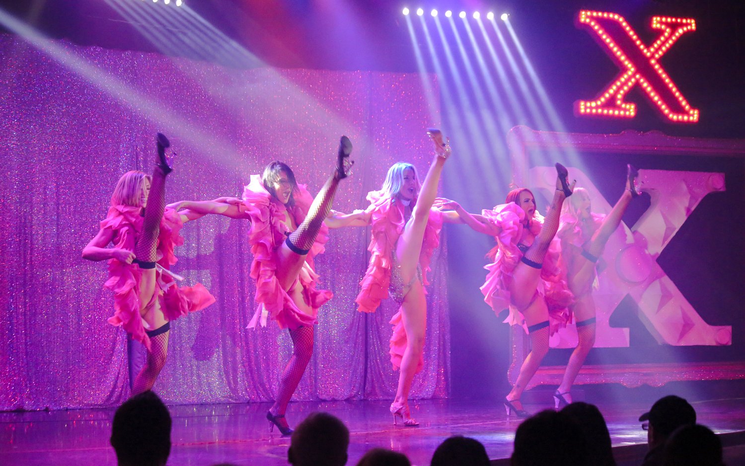 Performers in pink costumes dancing at X Burlesque - Kick'n Topless Revue, Las Vegas stage.