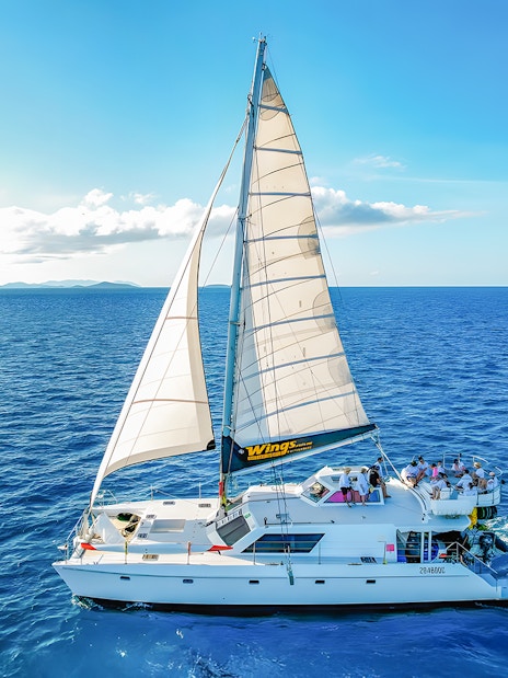 Tourists on a chartered catamaran sailing in the Whitsundays.