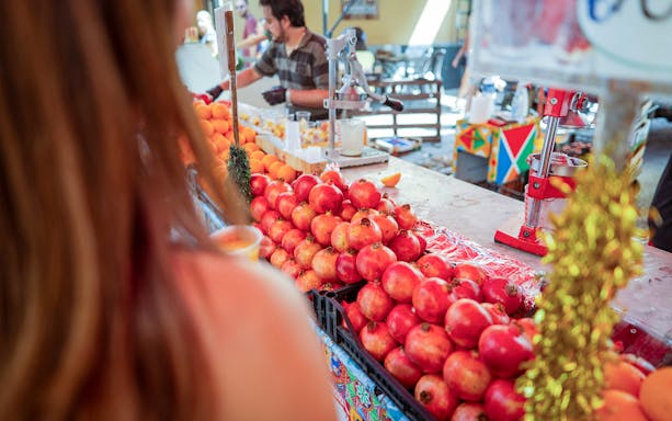 Pomegranates and oranges at a market stall during a guided art and food walking tour in Palermo.
