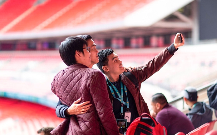 Visitors taking a selfie inside Wembley Stadium.