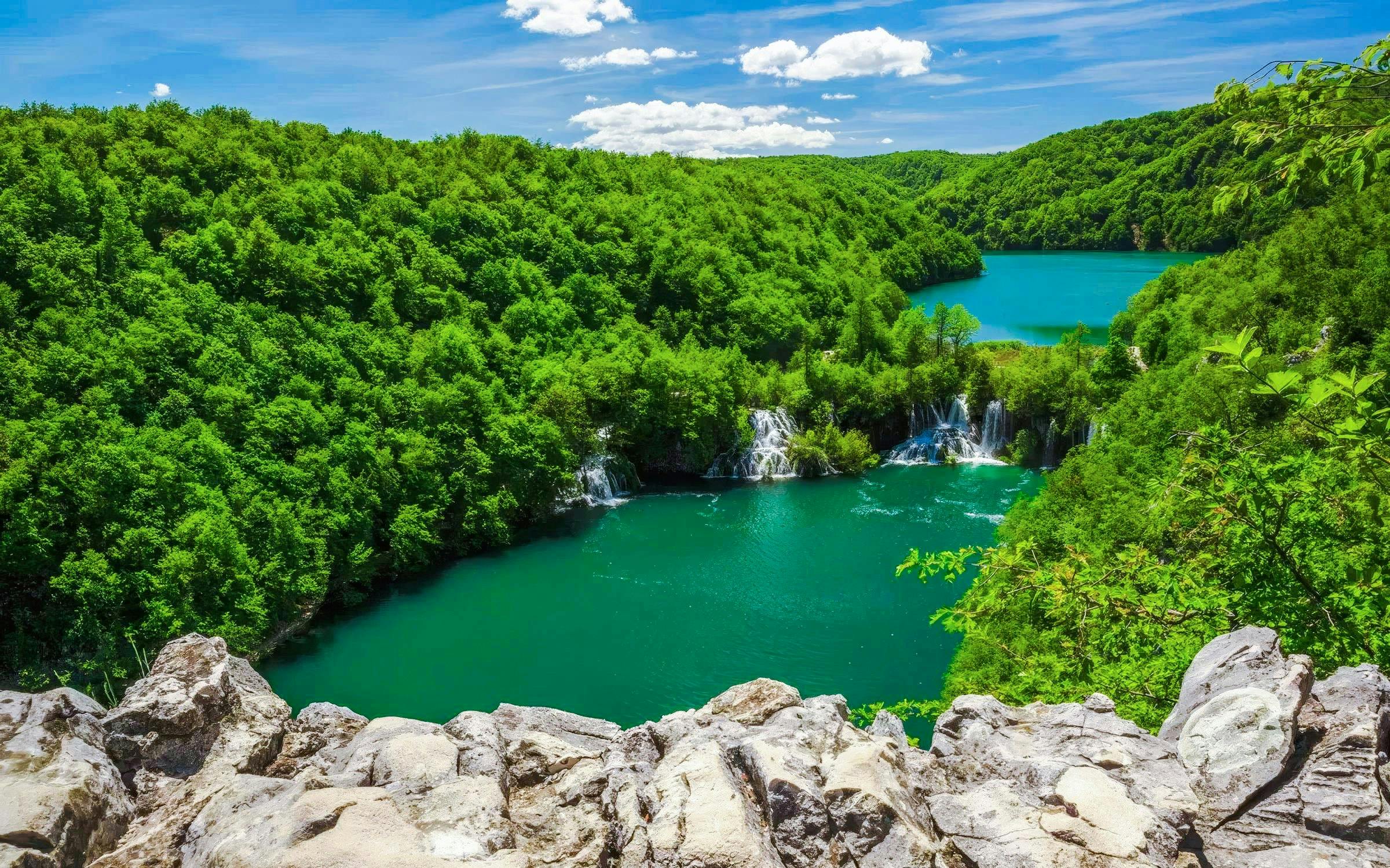 Plitvice Lakes waterfalls and lush greenery on Split to Zagreb private transfer route.