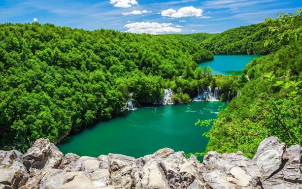 Plitvice Lakes waterfalls and lush greenery on Split to Zagreb private transfer route.