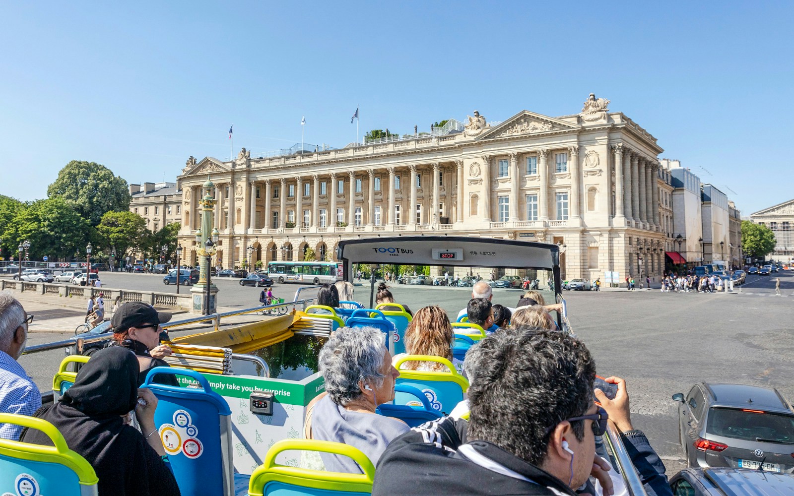 Tootbus passing Eiffel Tower in Paris, part of Hop-On Hop-Off Bus Tour with Seine River Cruise.
