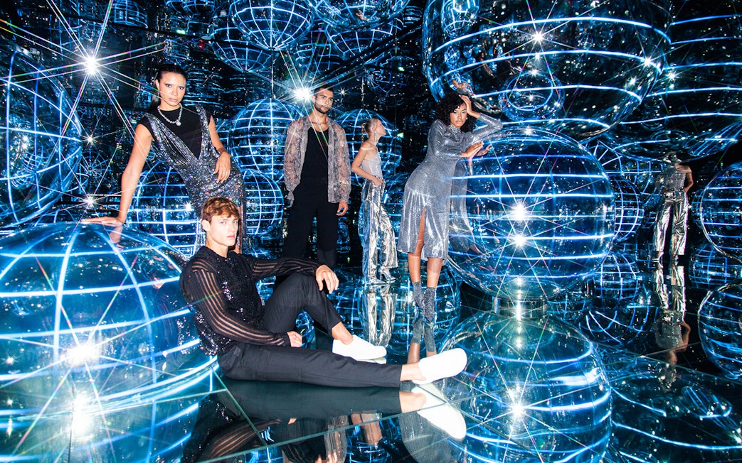 People exploring Luna installation at AYA Universe with reflective spheres and lights.