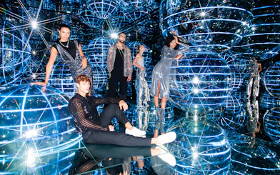 People exploring Luna installation at AYA Universe with reflective spheres and lights.