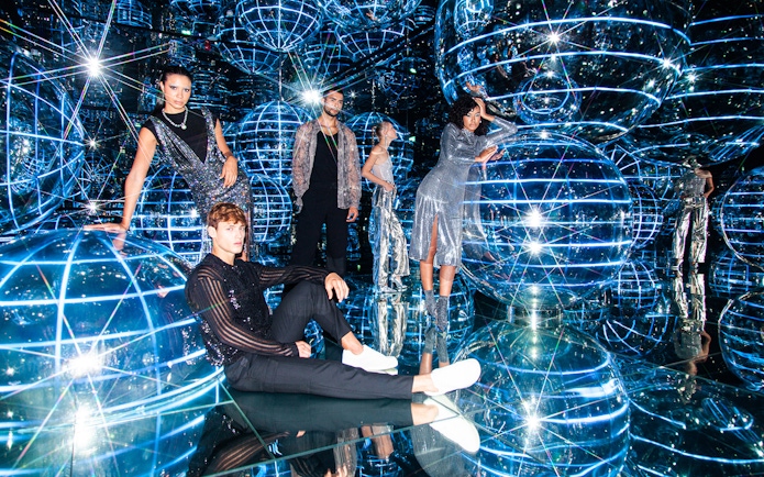 People exploring Luna installation at AYA Universe with reflective spheres and lights.