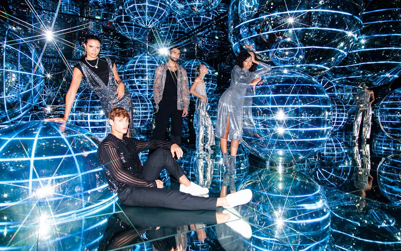 People exploring Luna installation at AYA Universe with reflective spheres and lights.