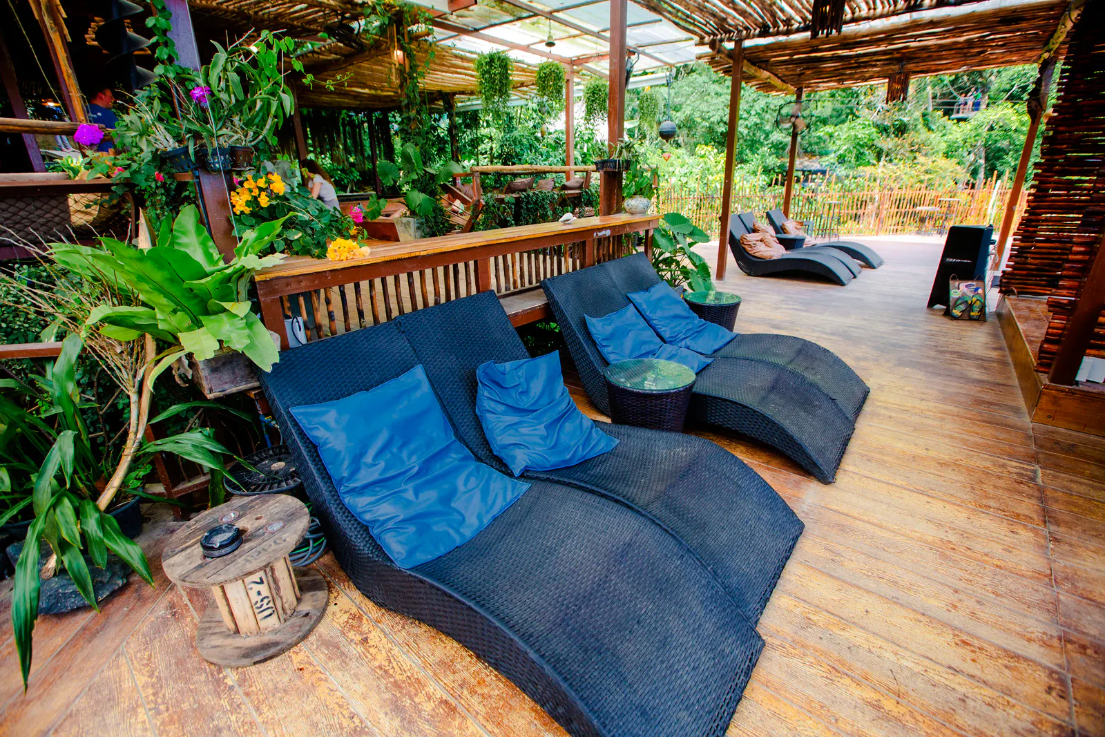 Outdoor seating area at Tree Bridge Zipline and Cafe, Koh Samui, surrounded by lush greenery.