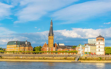 Riverside view of Düsseldorf with historic buildings and church spire on Panorama City Cruise.