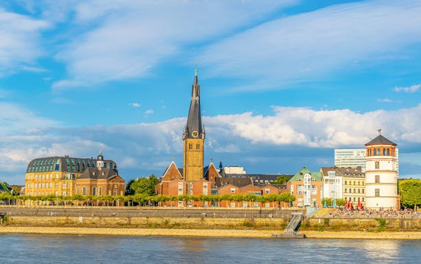 Riverside view of Düsseldorf with historic buildings and church spire on Panorama City Cruise.