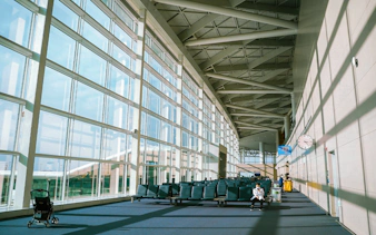 Incheon Airport terminal seating area with large windows and travelers.