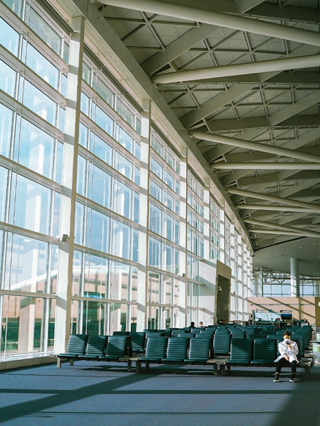 Incheon Airport terminal seating area with large windows and travelers.