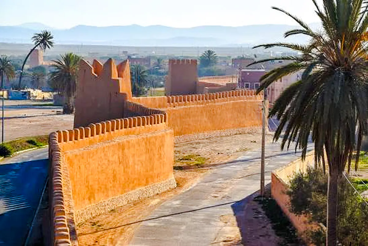 Ancient city walls and palm trees in Tiznit, Morocco, part of the Massa & Tiznit Jeep Safari.