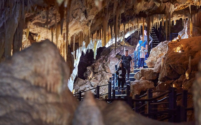 Visitors exploring stalactites in Ngilgi Cave during semi-guided tour.