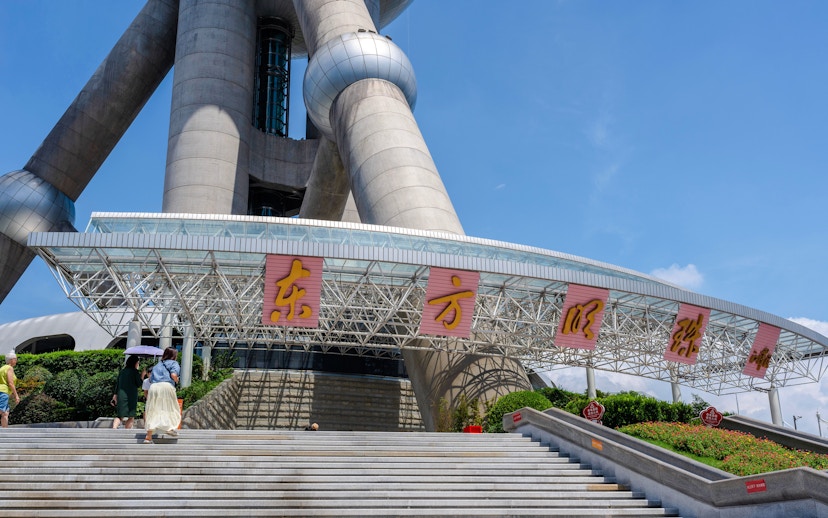 Entrance of Oriental Pearl Tower, Shanghai with visitors on steps.