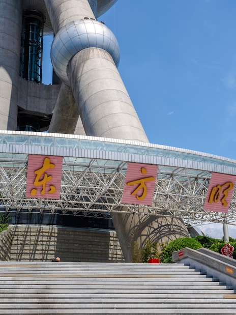Entrance of Oriental Pearl Tower, Shanghai with visitors on steps.