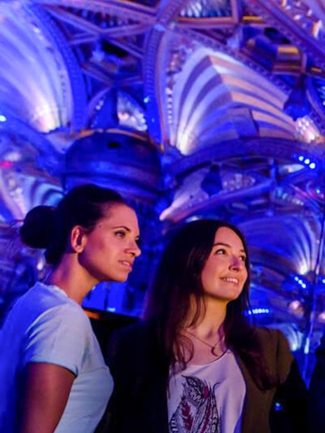 Visitors admire ornate ceiling at Grévin Paris Wax Museum.