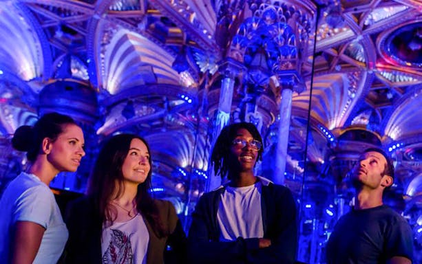 Visitors admire ornate ceiling at Grévin Paris Wax Museum.