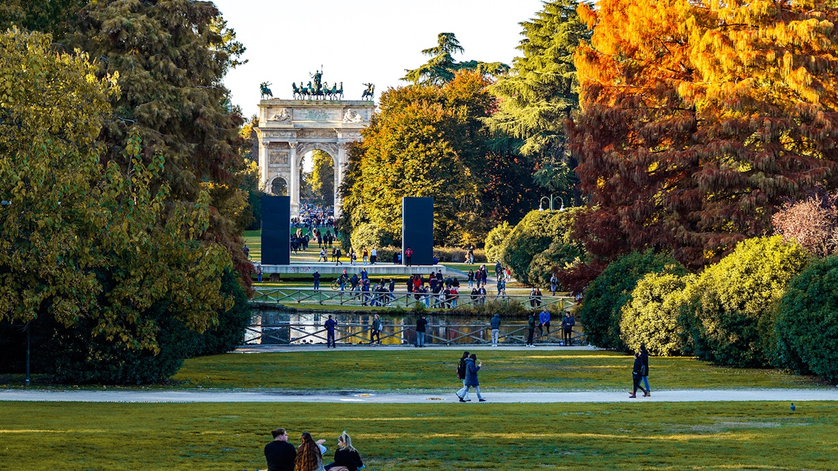Parco Sempione in Milan with autumn foliage and Sforza Castle in the background, Italy.