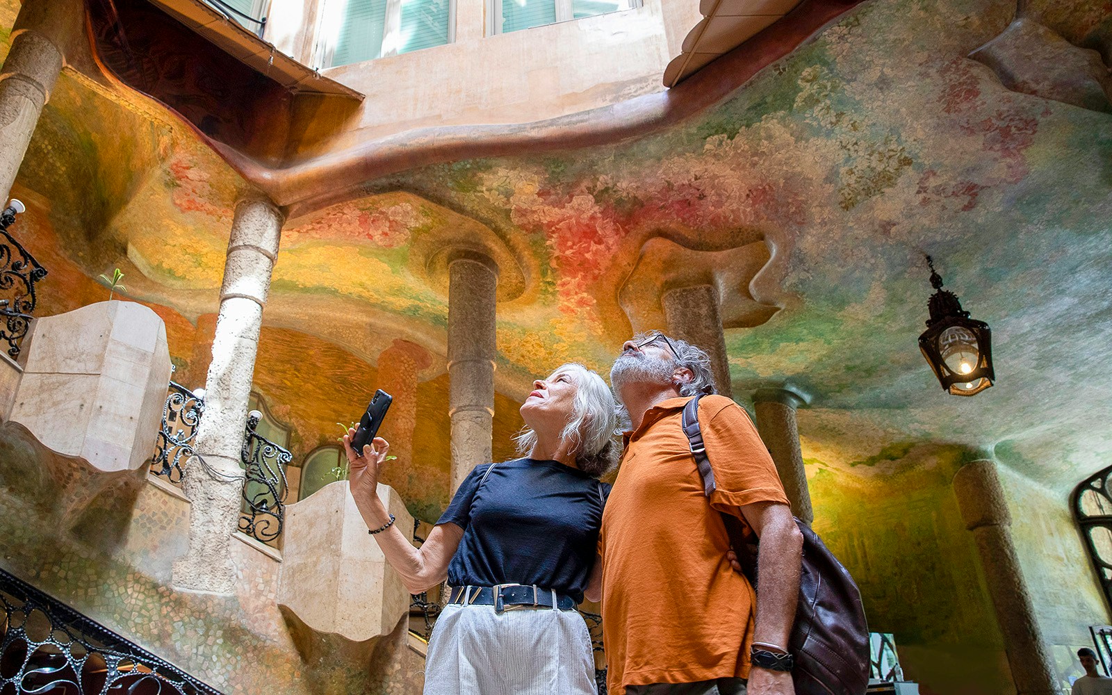 Visitors admiring the colorful interior of Casa Milà in Barcelona.