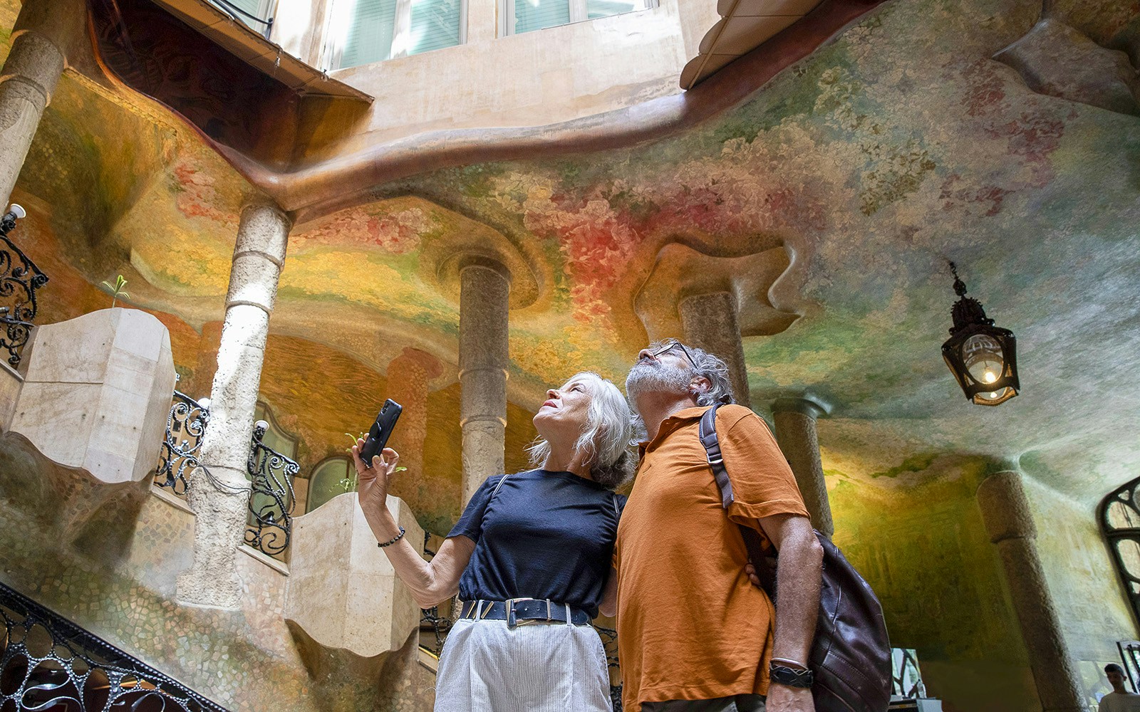 Visitors admiring the colorful interior of Casa Milà in Barcelona.