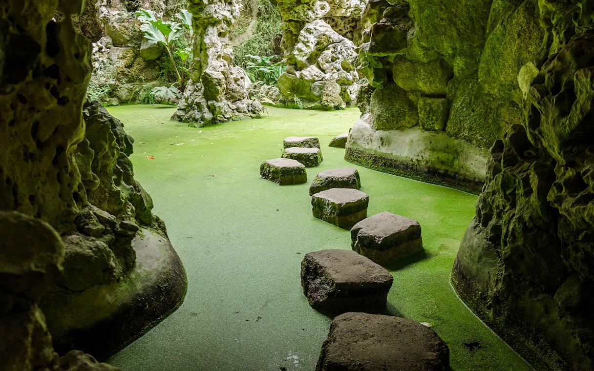 Stepping stones in a moss-covered grotto at Quinta da Regaleira, Sintra, Portugal.