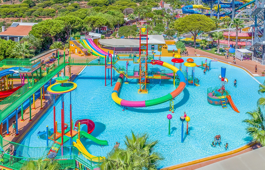 Children enjoying water slides at Mini Park Aquashow Park, Portugal.