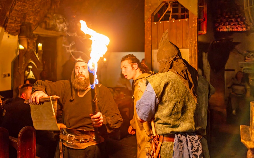 Medieval performers with torch at Dětenice Brewery dinner show near Prague.