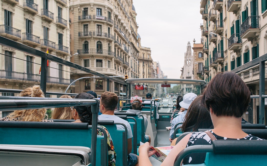 Tourists on an open-top bus touring Barcelona with Hola Barcelona Travel Card.