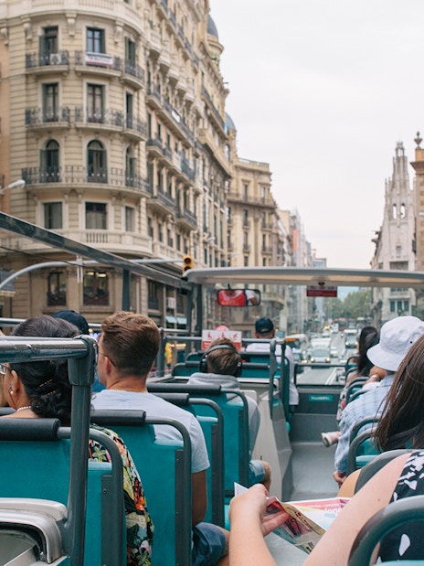 Tourists on an open-top bus touring Barcelona with Hola Barcelona Travel Card.