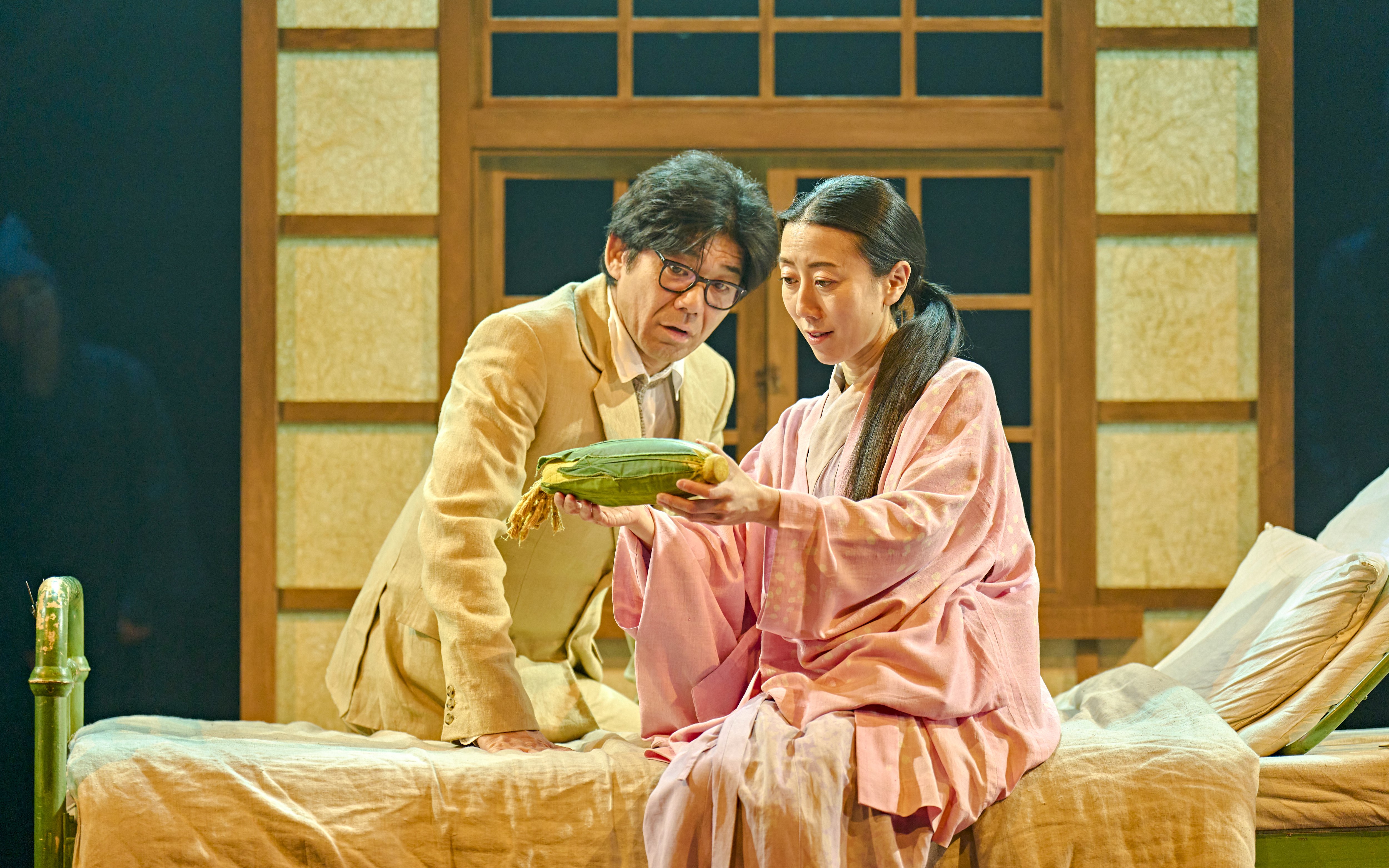 Two actors in a stage production of My Neighbour Totoro, examining a corn cob.
