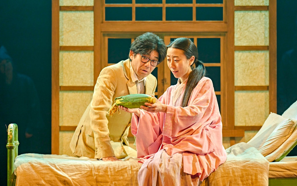 Two actors in a stage production of My Neighbour Totoro, examining a corn cob.
