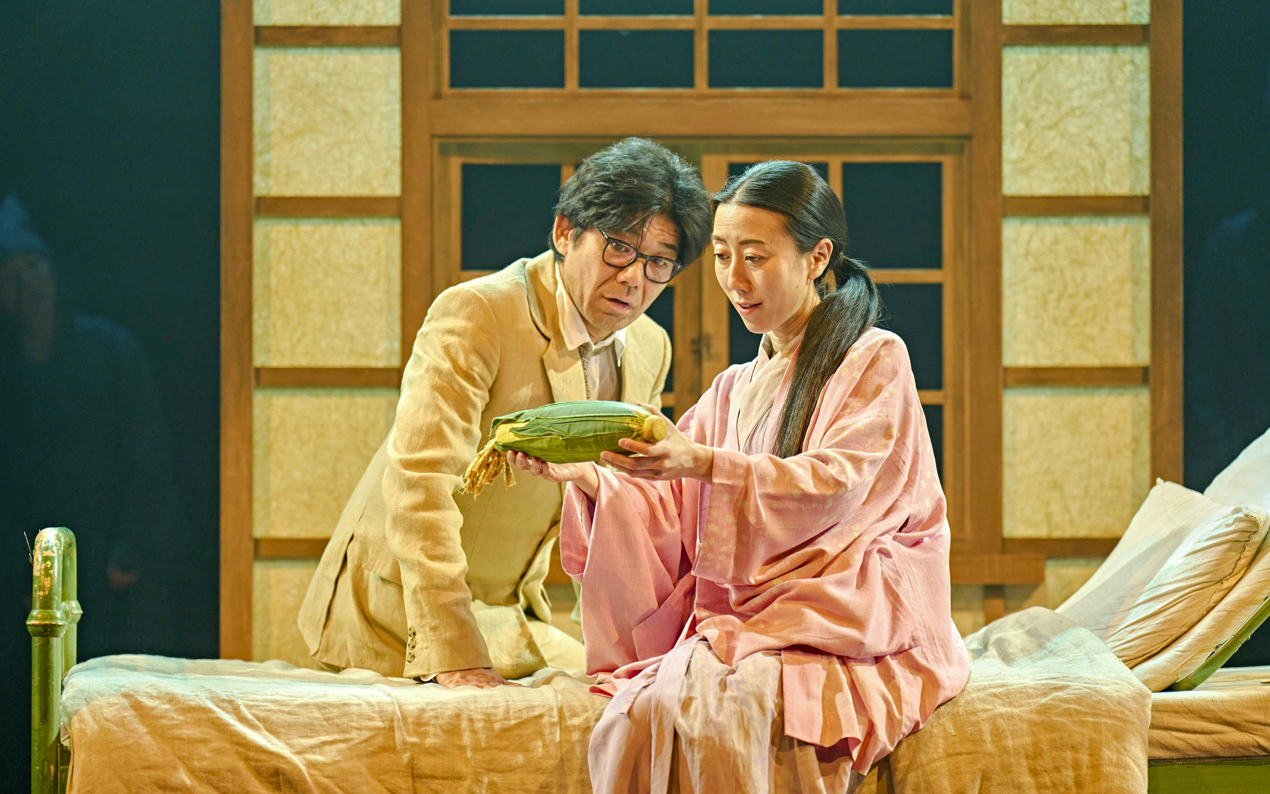 Two actors in a stage production of My Neighbour Totoro, examining a corn cob.
