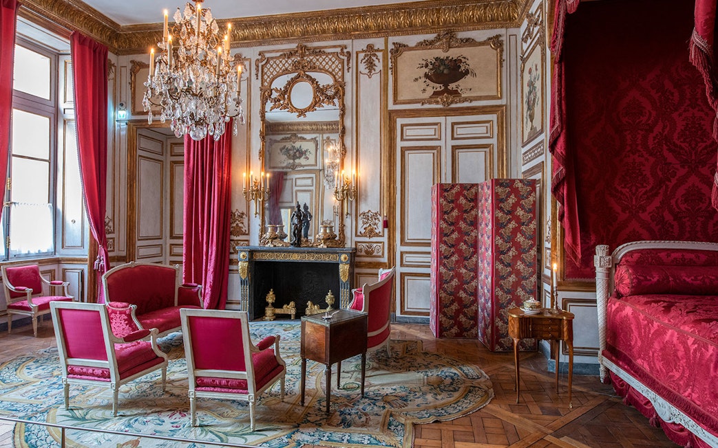 Elegant room with red furnishings and chandelier at Hôtel de la Marine, Paris.