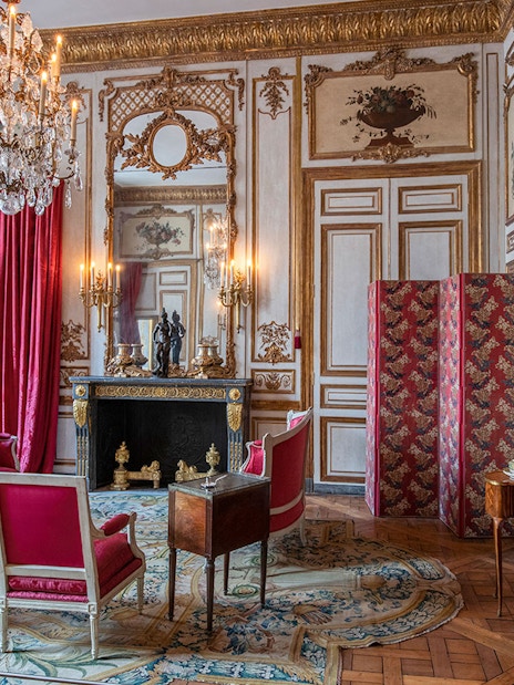 Elegant room with red furnishings and chandelier at Hôtel de la Marine, Paris.