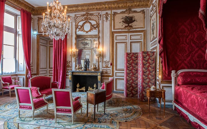 Elegant room with red furnishings and chandelier at Hôtel de la Marine, Paris.
