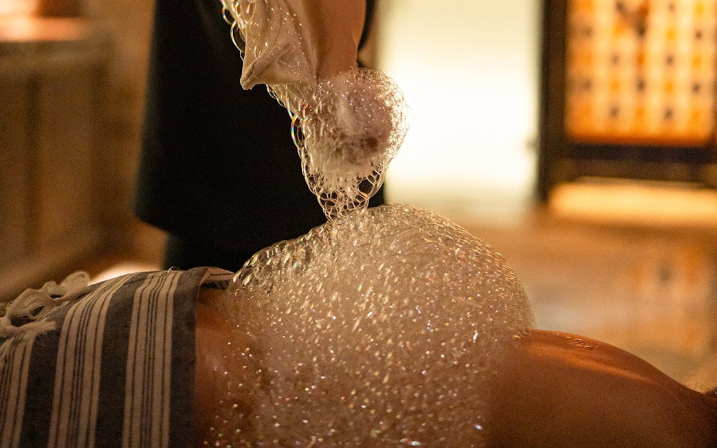 Visitors enjoying a bubble bath in a traditional Hammam in Granada.