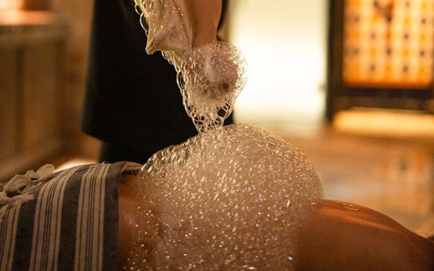 Visitors enjoying a bubble bath in a traditional Hammam in Granada.