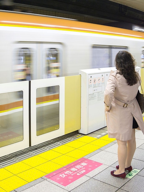 Tokyo subway platform with passengers waiting for a train.