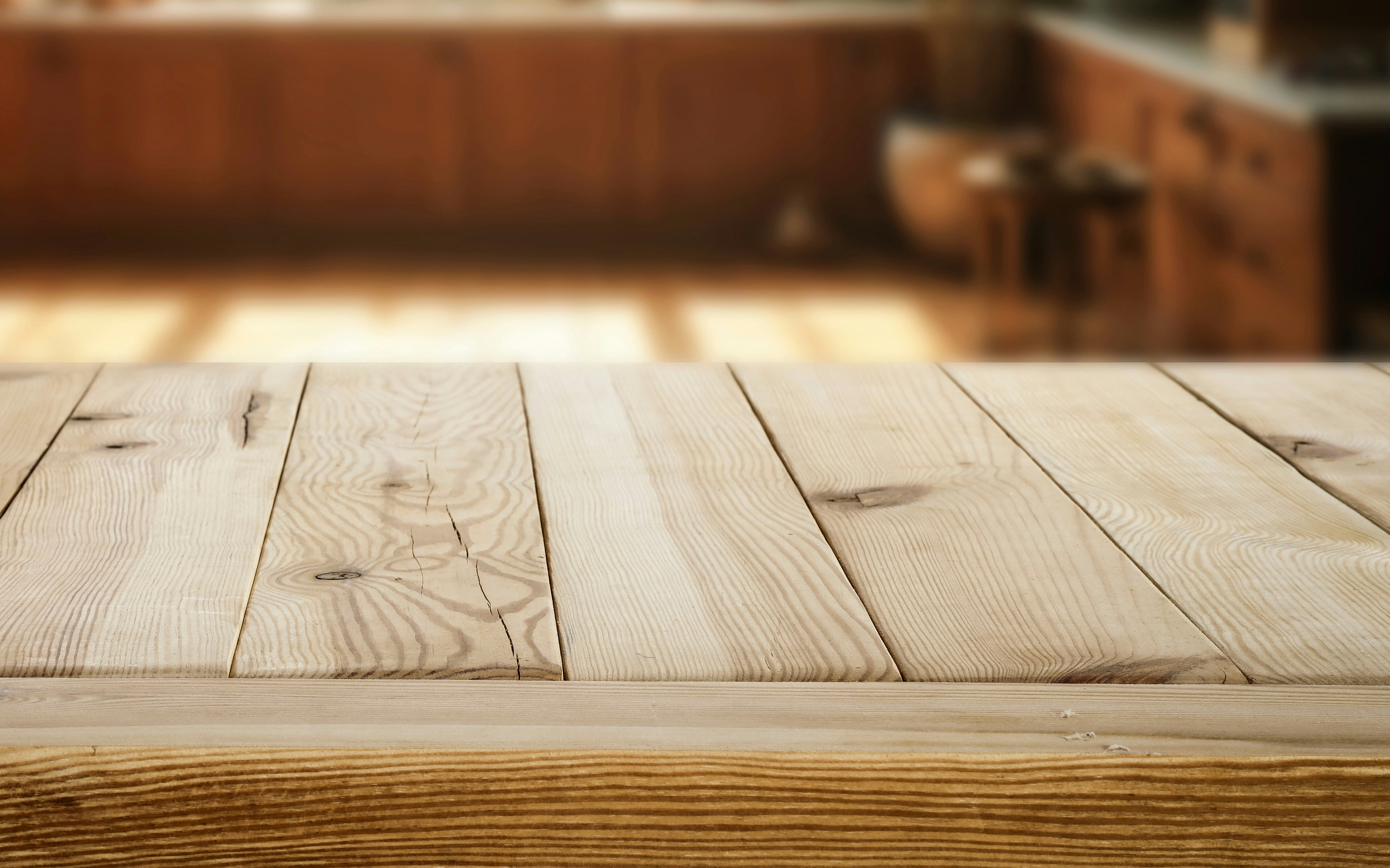 Wooden bench surface with blurred background in a cozy setting.