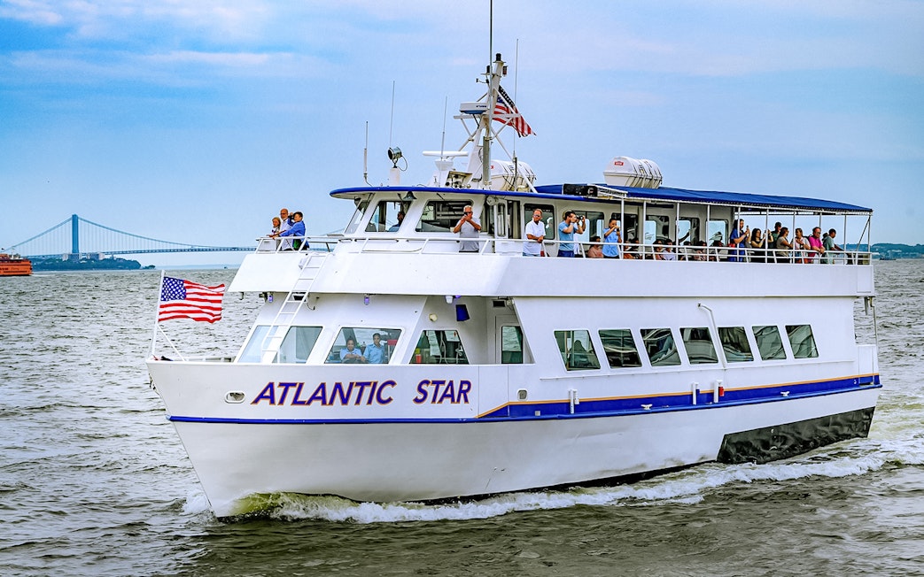 Tourists on the Atlantic Star cruise near New York City with the Verrazzano-Narrows Bridge in view.