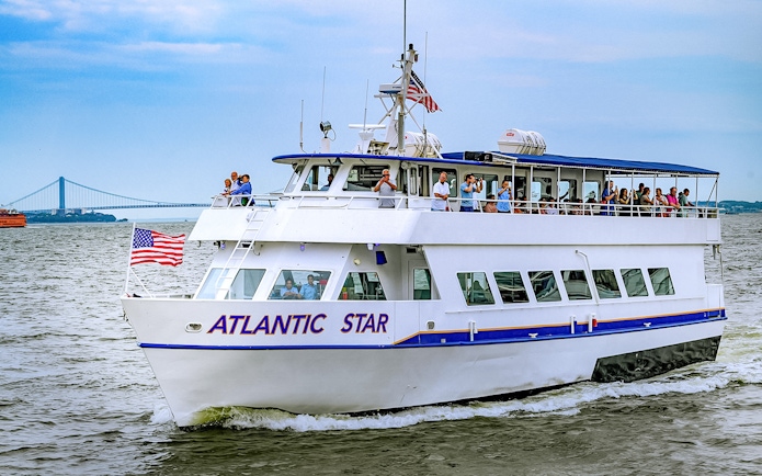 Tourists on the Atlantic Star cruise near New York City with the Verrazzano-Narrows Bridge in view.